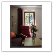 Wohnzimmer mit Fenster und rotem Sessel