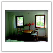Essbereich mit Tisch, Stühlen und Blumen in den Fenstern